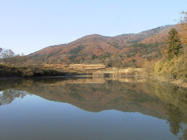 眼下に池が広がり、水面に逆さ宝鏡山が写っている写真