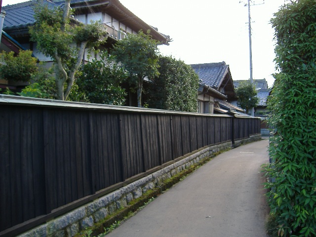 瓦屋根の家が建ち並び、木と石で造られた壁が長く続いている北太田集落の写真