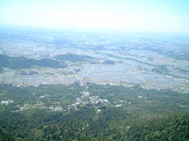 小さな山や田畑、街並みが広がっている筑波山山頂からのつくば市の写真