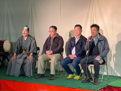 頭にちょんまげのカツラを被っている着物を着た男性と3名の男性が横一列にパイプ椅子に座り右側の男性がマイクを持って話をしている伊賀七BRAND DAYの様子の写真