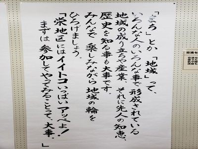 紙に地域のスローガンが縦書きで書かれて壁に貼られている写真