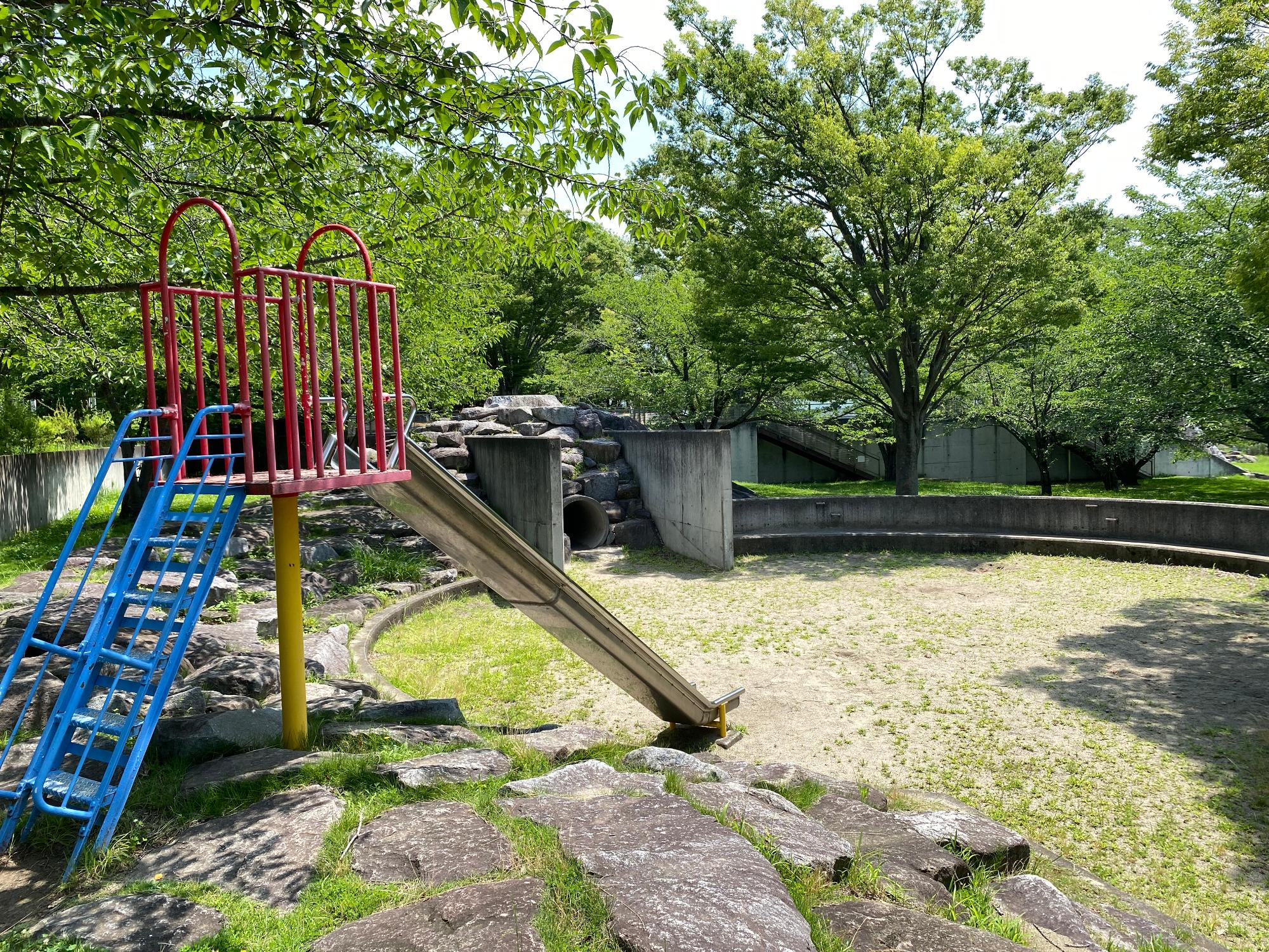 石の築山や遊具のある反町の森公園の写真