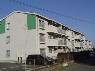 駐車場が設けられている3階建ての駒形団地3号棟、4号棟、5号棟のバルコニー側を左斜めから撮影した写真
