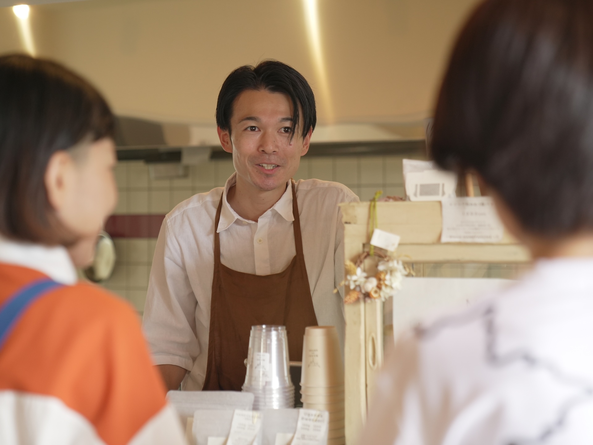 お客さんにコーヒー豆の説明をする鷲尾さん