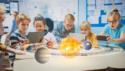 VRで映し出された宇宙空間をタブレットやスマートフォンで見ている子供たちの写真
