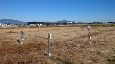 農地の一角に機械が置かれ実験が行われている写真