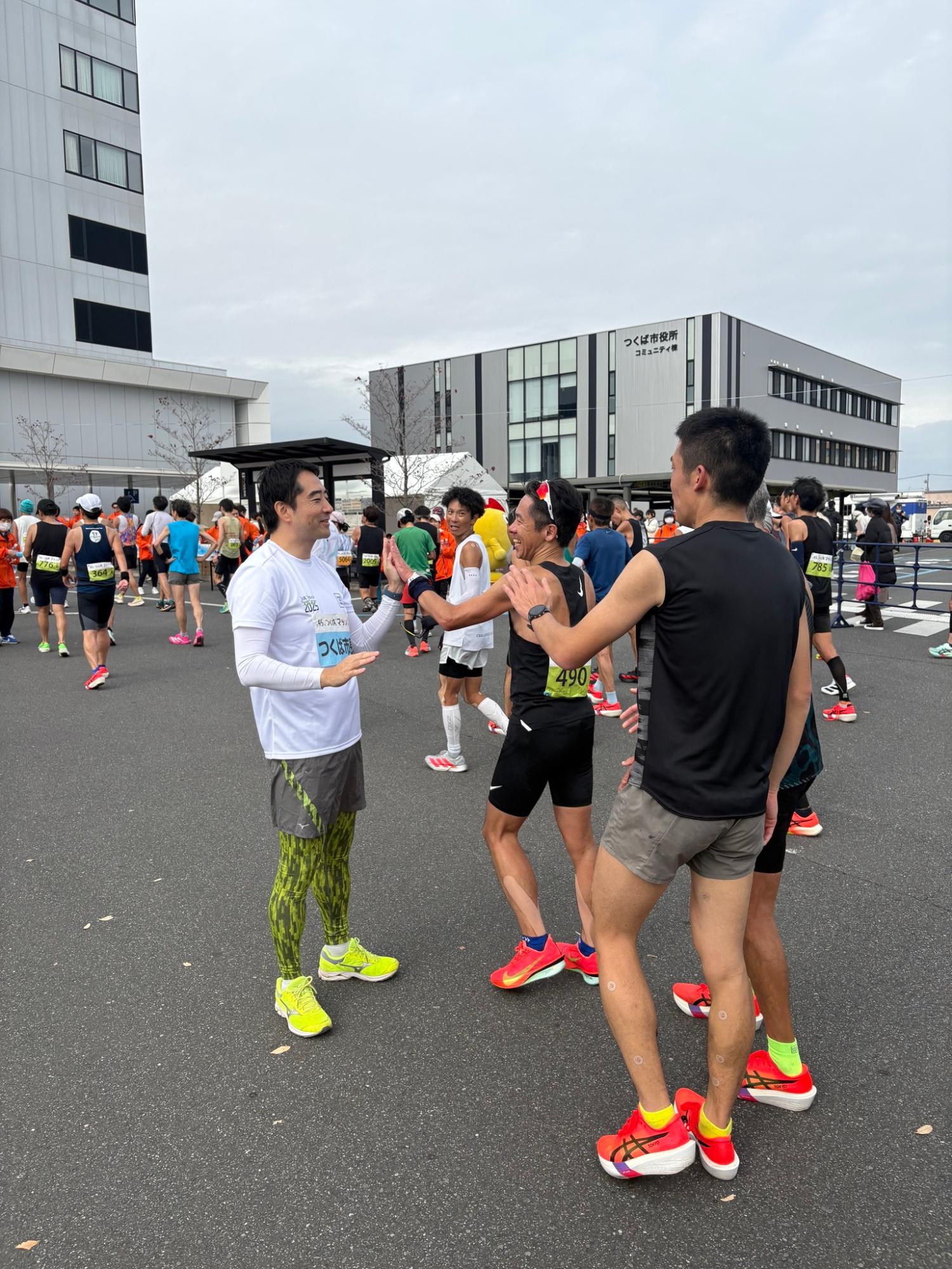 つくばマラソン、フルマラソンのゴール地点でランナーとハイタッチする市長