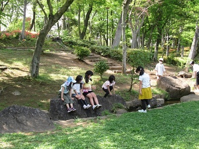 3人の女の子が大きな石の上に座っているの写真