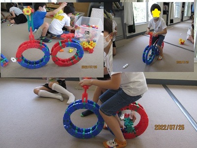 ブロックで作ったおもちゃの自転車に座っているこどもの写真