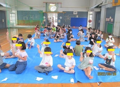 かき氷を食べているこども達が挙手をしている写真