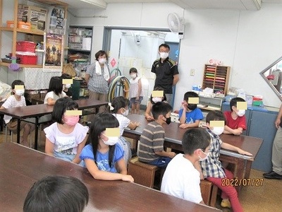 こども達が説明を聞いている実験隊の様子写真