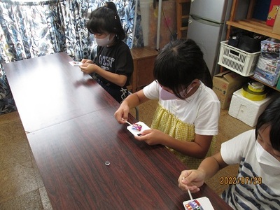 こども達がカラフルな色が付いた棒付のプレートを持っている写真