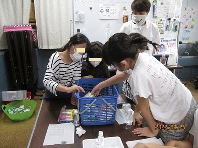 カゴの中に用意されたプラスチックのラベルを選んでいるこども達の写真