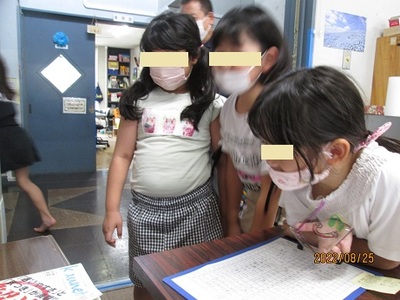 トースターの中のプラバンが縮む様子をみているこども達の写真