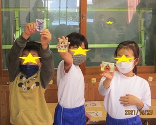作品と一緒にポーズをとる子供たちの写真