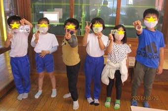 作品とポーズをとる子供たちの写真