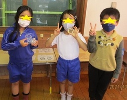 作品とポーズをとる子供たちの写真