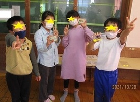 作品とポーズをとる子供たちの写真