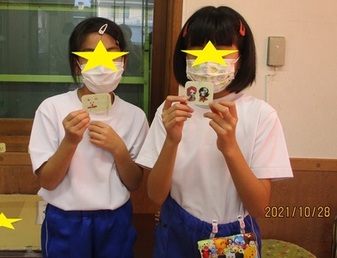 作品とポーズをとる子供たちの写真