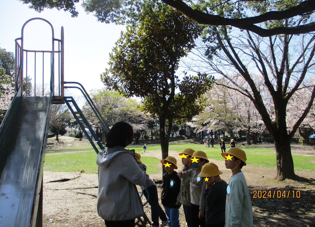 公園の滑り台で遊ぶ際の注意や説明を聞く子供たち