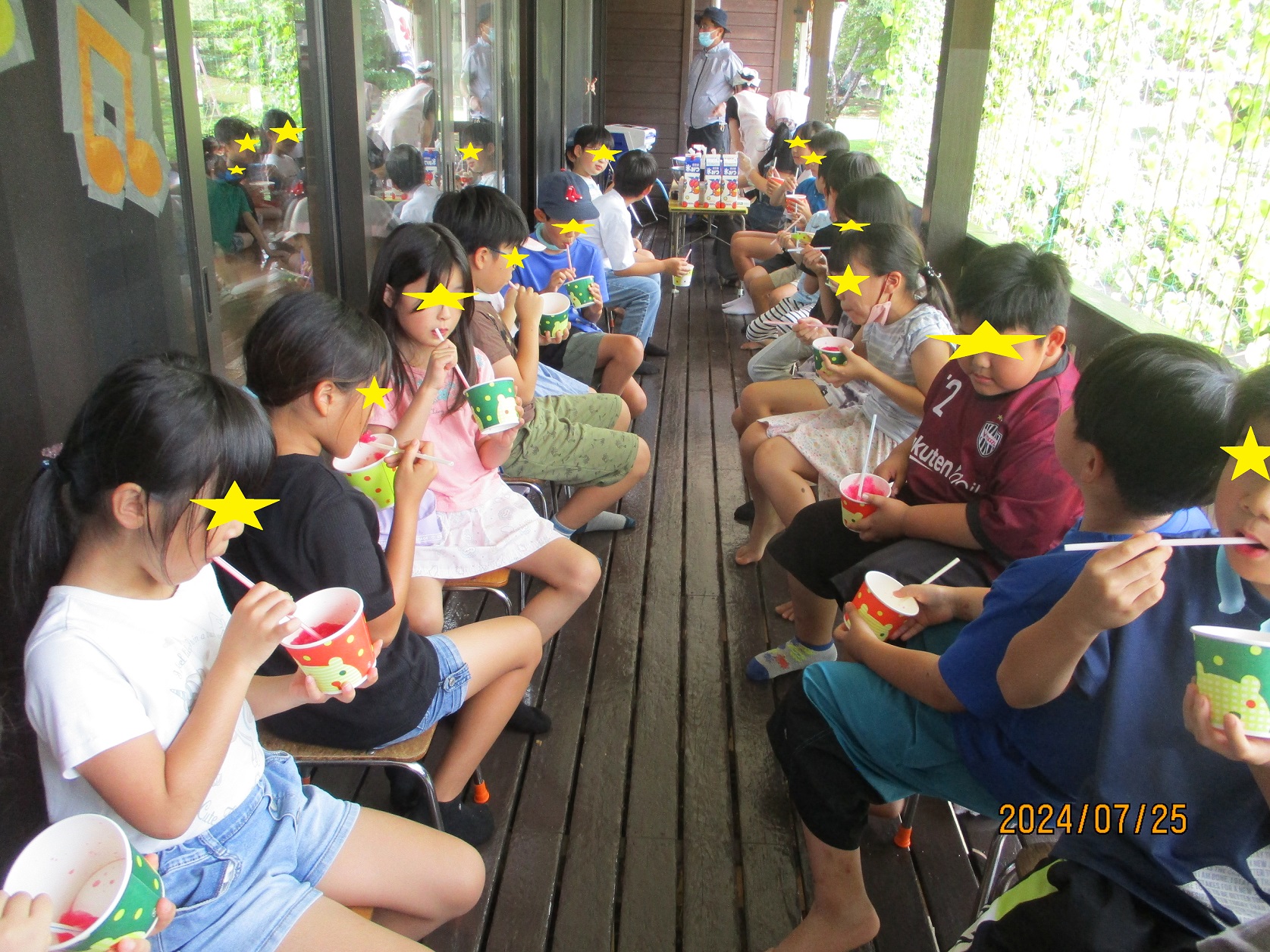 児童館のベランダでかき氷を食べる子供たち