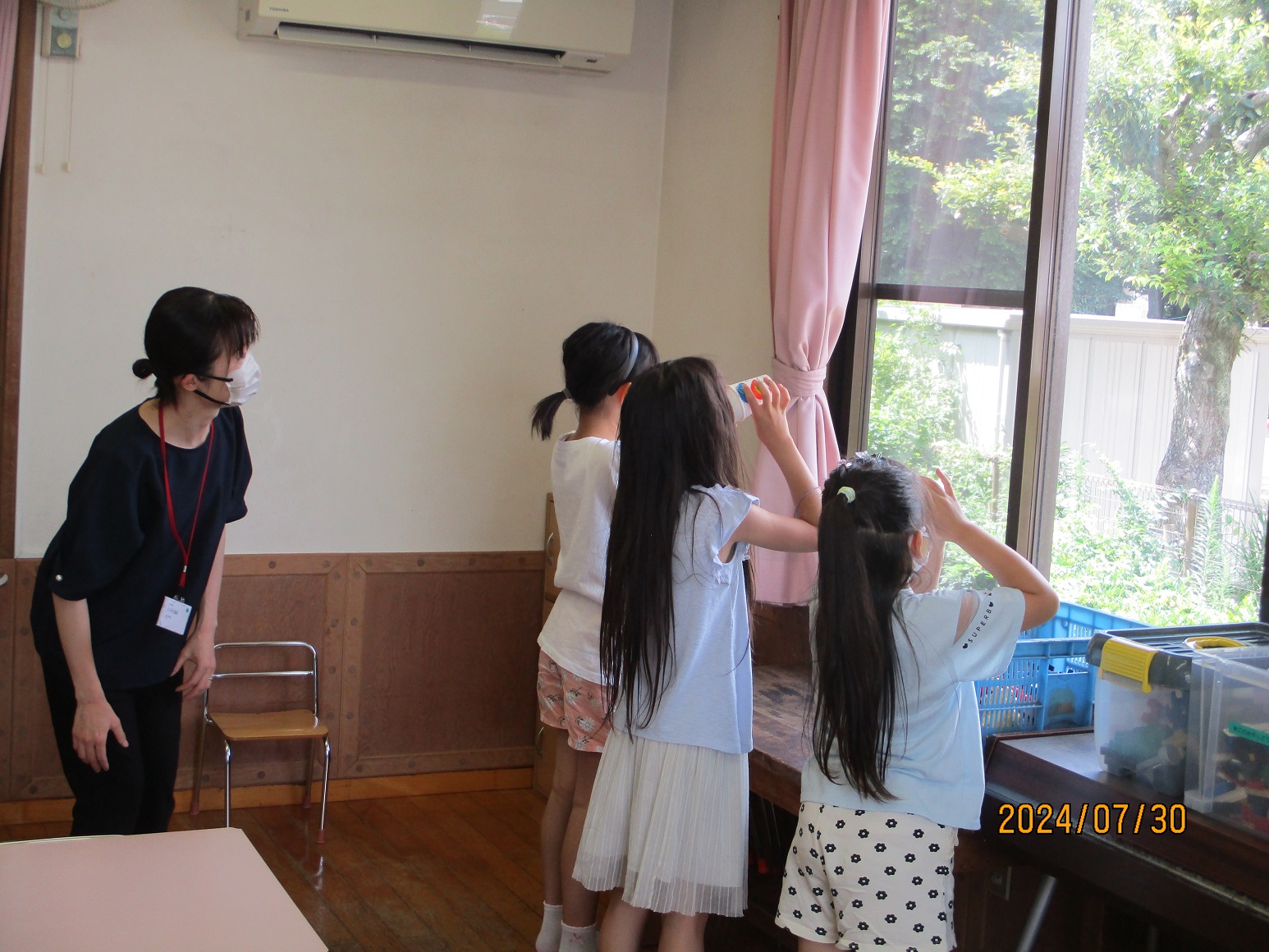 自分たちで作った万華鏡を覗く子供たち