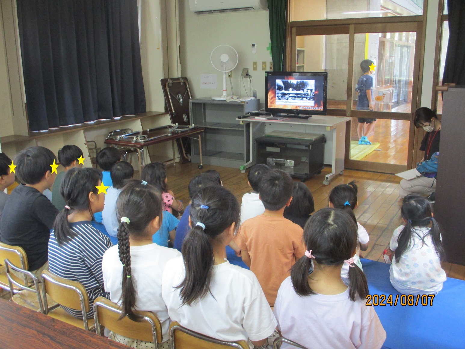 真剣に火災についてのDVDを観る子供たち
