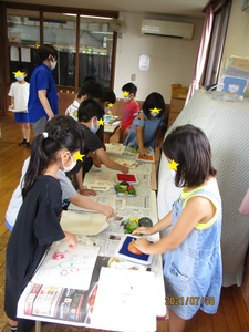 野菜スタンプを押す子どもたちの写真