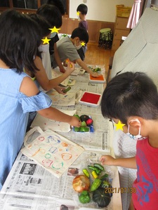 野菜スタンプを押す子どもたちの写真