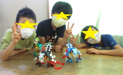 ラキューの作品と一緒にピースをする3人の男の子の写真