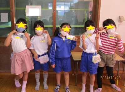 作品とポーズをとる子どもたちの写真