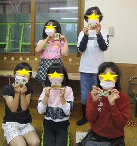 作品とポーズをとる子供たちの写真