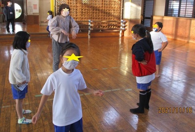 室内運動場で体操をする子どもたちの写真