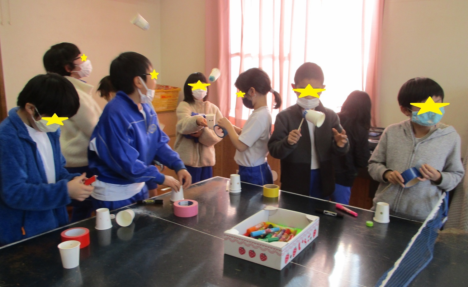 コップを使って工作をする子供たち