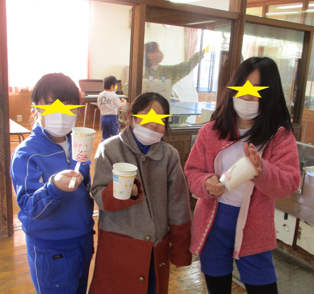 作ったコップでポンを見せてポーズをとる子供たち