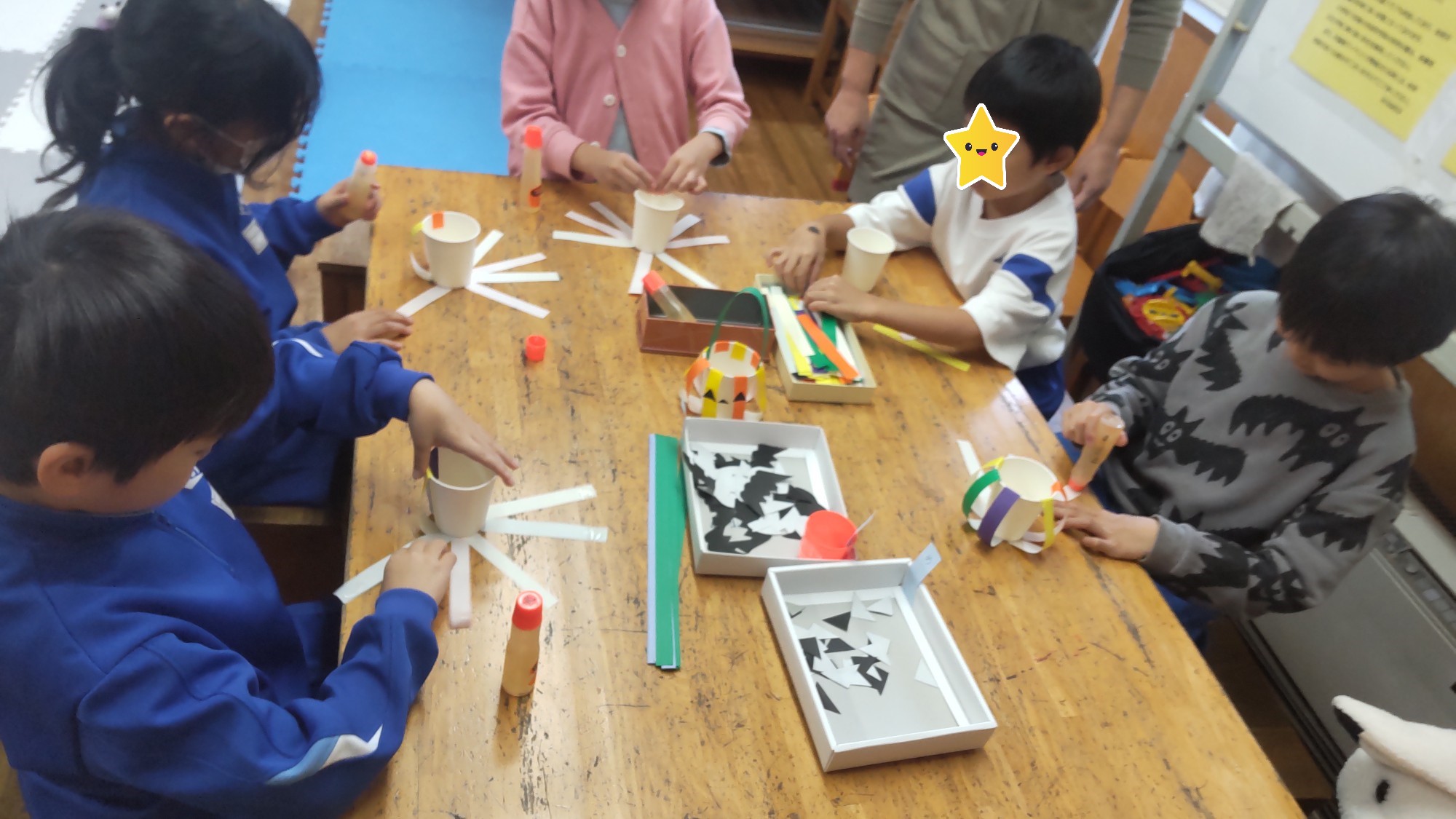 紙コップに貼った折り紙をふんわりとかぼちゃ形になるように張っている所