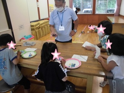 お皿にビー玉を移す子供たちの写真