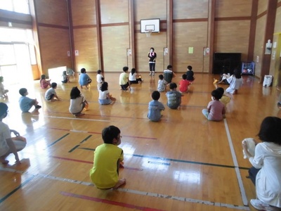 体育館で先生が子どもたちに説明している写真