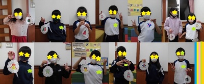 出来たクリスマスの飾りを手に持っている子供たちの写真