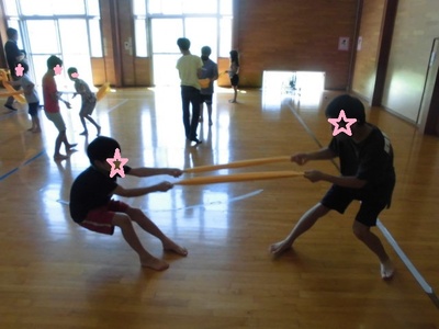 二人の子どもがタオルの引っ張り合いをしている写真
