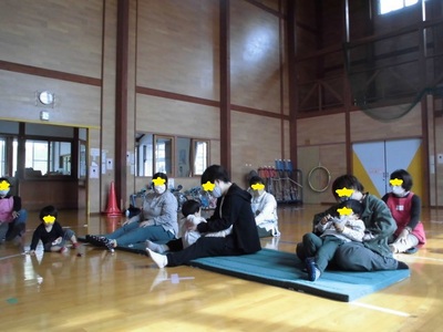 足の上に乗せて身体を揺らしたりくすぐったりと触れ合いを楽しむ親子の写真
