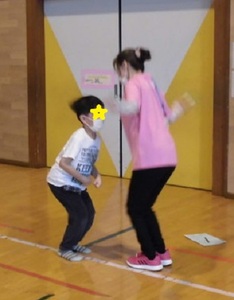 先生と一緒に縄跳びをする子供の写真