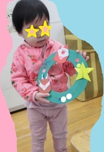 出来上がったリースを持つ子どもの写真