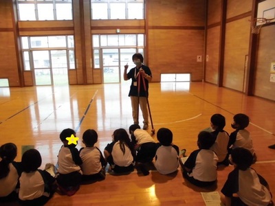 体育館で先生が子どもたちが竹馬の説明を様子