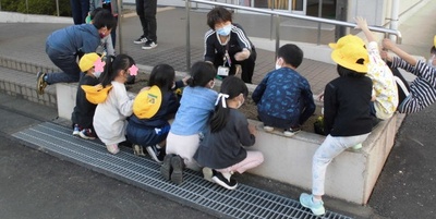 花壇に子供たちが集まりのぞき込んでいる様子の写真