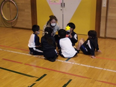 先生と子供たちが集まり作戦会議している様子の写真
