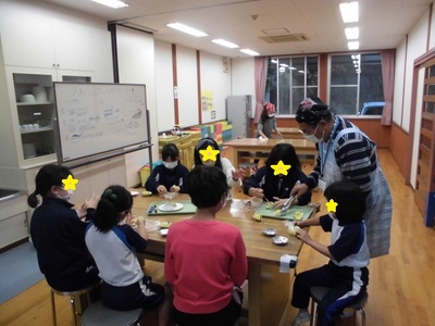 机で子供たちがスウィートポテトを丸めている様子の写真
