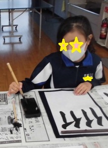 子どもが半紙に人偏を4回書いて練習している様子の写真