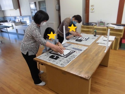 先生が子どもに筆の使い方を教えている様子の写真