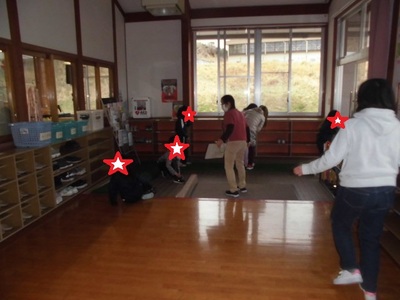 スタッフに促され急いで玄関で靴を履いている子供たちの写真